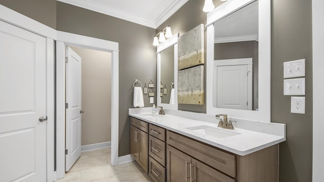 full bath with double vanity, a sink, crown molding, and baseboards