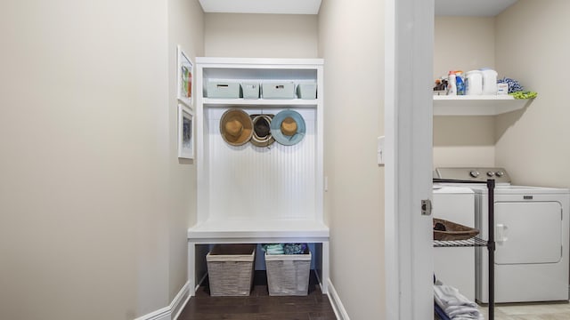 washroom featuring baseboards, washer and dryer, laundry area, and wood finished floors