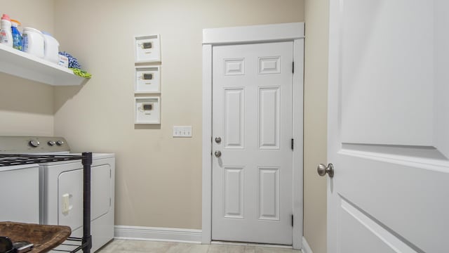 laundry area with baseboards, washer and dryer, and laundry area