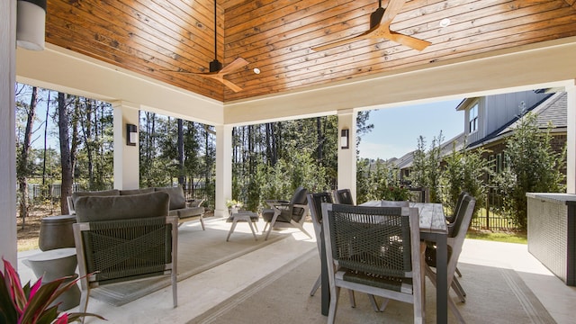 view of patio with fence, outdoor dining space, and a ceiling fan