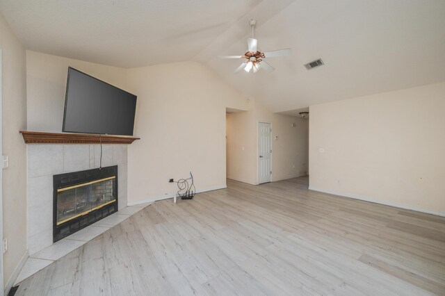 528 Hyde Park Dr, Crestview, FL 32539 - unfurnished living room with vaulted ceiling, a tile fireplace, wood finished floors, visible vents, and ceiling fan