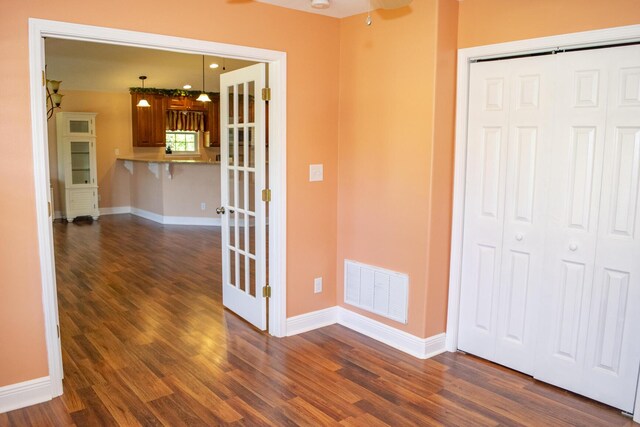 interior space featuring a closet, visible vents, baseboards, and dark wood-style flooring
