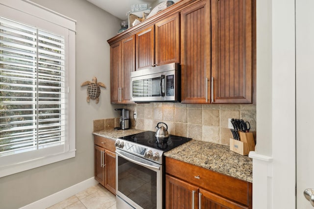 26 Classic Court Ln, Santa Rosa Beach, FL 32459 - kitchen with brown cabinetry, tasteful backsplash, appliances with stainless steel finishes, and light stone countertops