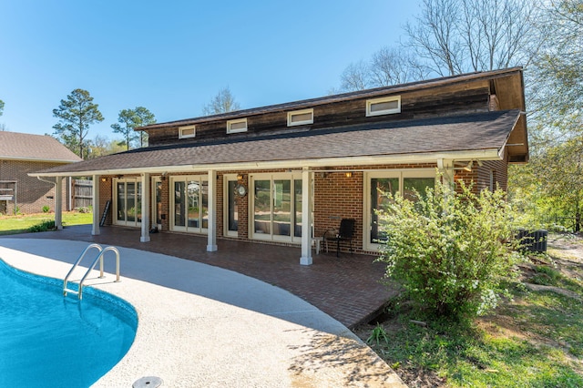 24776 Fifth Ave, Florala, AL 36442 - rear view of property featuring fence, roof with shingles, an outdoor pool, brick siding, and a patio area