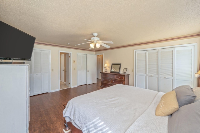24776 Fifth Ave, Florala, AL 36442 - bedroom with two closets, crown molding, ceiling fan, a textured ceiling, and dark wood-style flooring