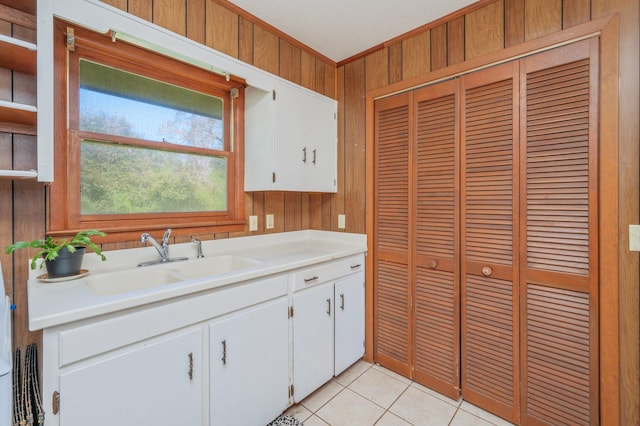 24776 Fifth Ave, Florala, AL 36442 - kitchen with light tile patterned floors, wood walls, light countertops, and a sink