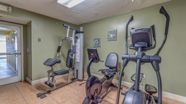 10519 Front Beach Rd Unit 1904B, Panama City Beach, FL 32407 - exercise room with baseboards, a textured ceiling, and tile patterned flooring