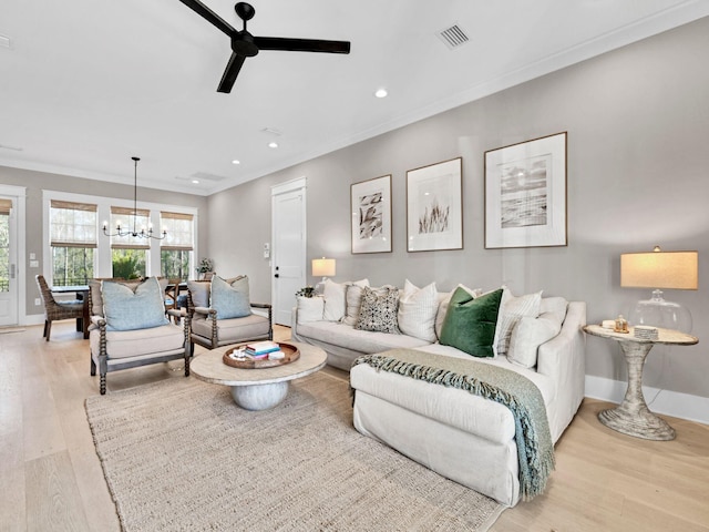 290 White Cottage Rd, Santa Rosa Beach, FL 32459 - living room featuring visible vents, baseboards, ornamental molding, light wood finished floors, and ceiling fan with notable chandelier