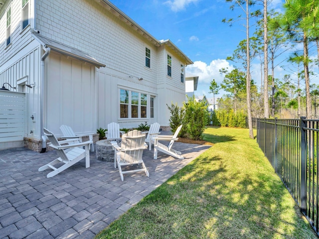 290 White Cottage Rd, Santa Rosa Beach, FL 32459 - rear view of property featuring board and batten siding, a patio area, an outdoor fire pit, fence, and a yard