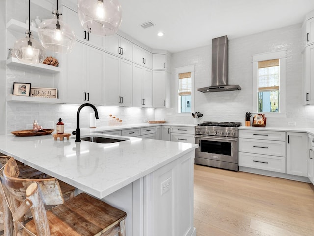 290 White Cottage Rd, Santa Rosa Beach, FL 32459 - kitchen featuring stainless steel stove, wall chimney exhaust hood, a peninsula, and plenty of natural light