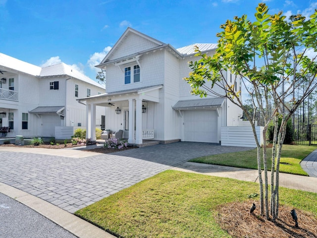 290 White Cottage Rd, Santa Rosa Beach, FL 32459 - view of front of home featuring board and batten siding, covered porch, a standing seam roof, decorative driveway, and an attached garage