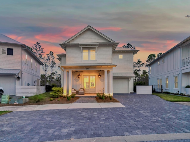 290 White Cottage Rd, Santa Rosa Beach, FL 32459 - traditional-style home featuring a porch, decorative driveway, board and batten siding, an attached garage, and french doors