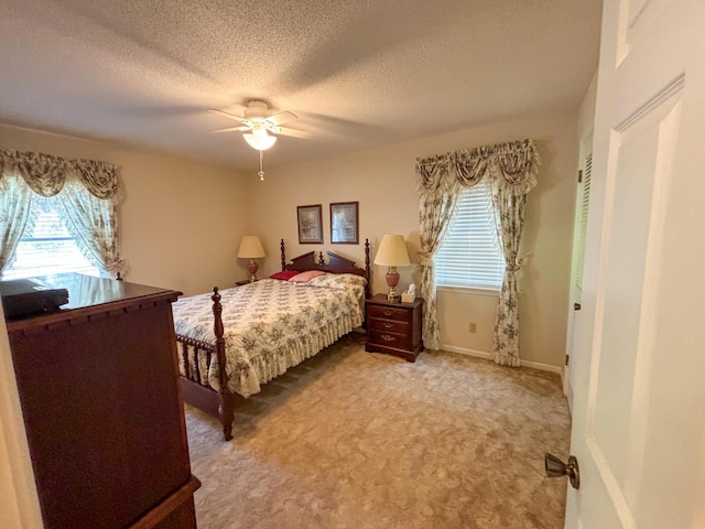 bedroom with carpet floors, a textured ceiling, multiple windows, and a ceiling fan