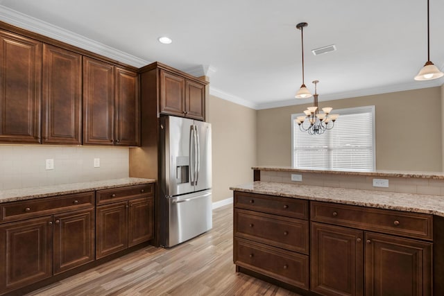 kitchen featuring light wood-style flooring, visible vents, stainless steel refrigerator with ice dispenser, and decorative light fixtures