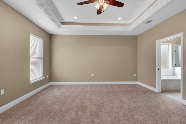 empty room with baseboards, visible vents, ceiling fan, and a raised ceiling