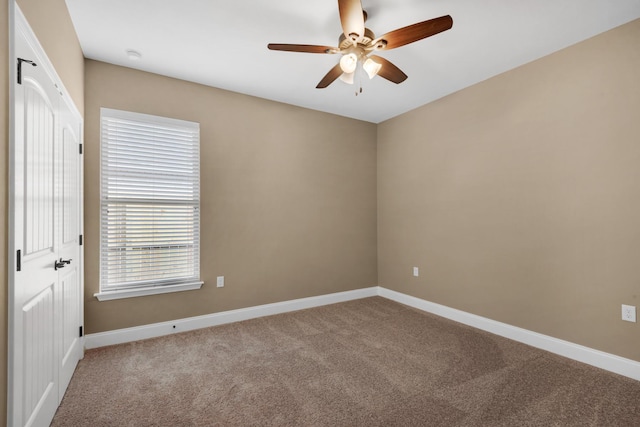 empty room with a ceiling fan, carpet floors, and baseboards