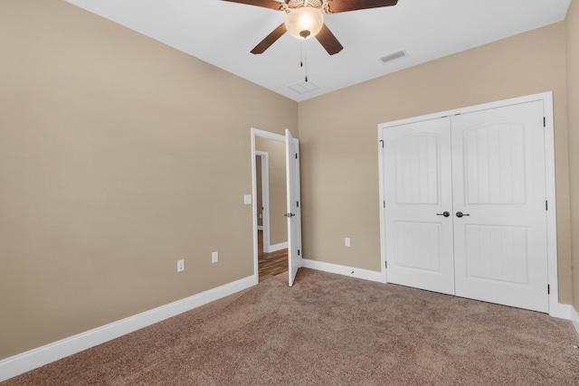 unfurnished bedroom featuring a closet, carpet floors, a ceiling fan, baseboards, and visible vents