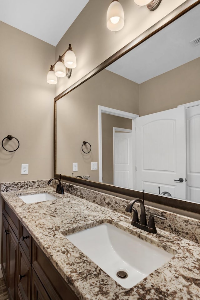 full bathroom featuring double vanity, a sink, and visible vents