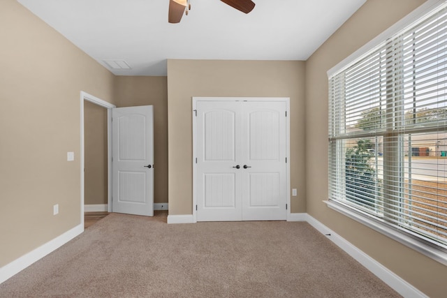 unfurnished bedroom featuring baseboards, carpet flooring, and a closet