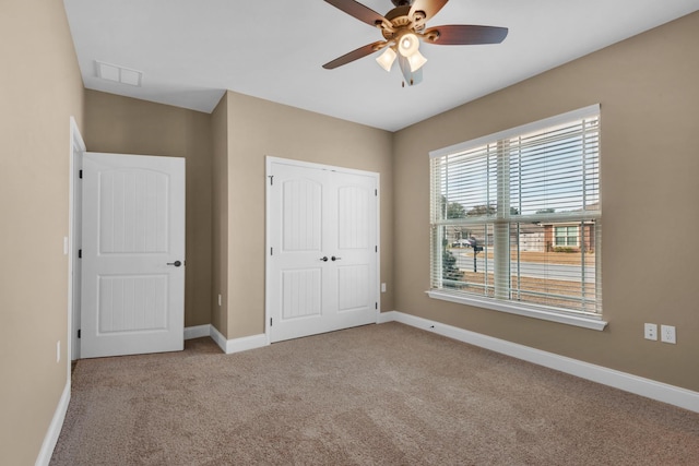 unfurnished bedroom with a closet, a ceiling fan, baseboards, visible vents, and carpet
