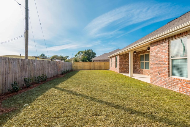 view of yard featuring a fenced backyard, a patio area, and a ceiling fan