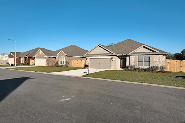 view of front of property with fence, an attached garage, brick siding, a front lawn, and driveway