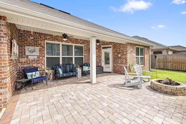 view of patio with an outdoor fire pit, ceiling fan, and fence