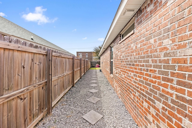 view of home's exterior featuring brick siding and fence
