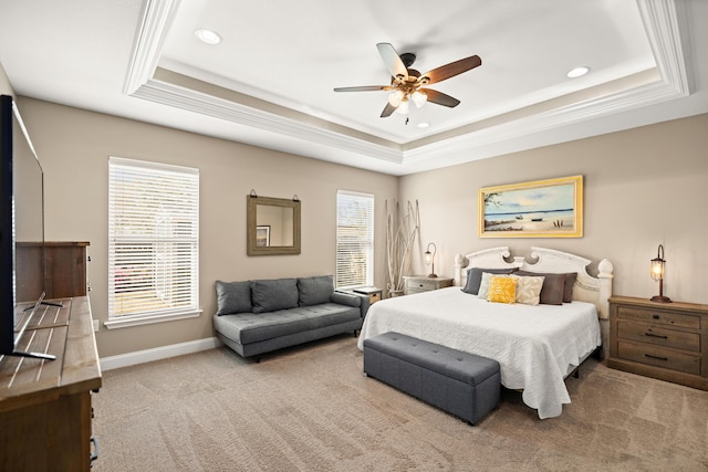 bedroom with carpet flooring, a tray ceiling, baseboards, and crown molding
