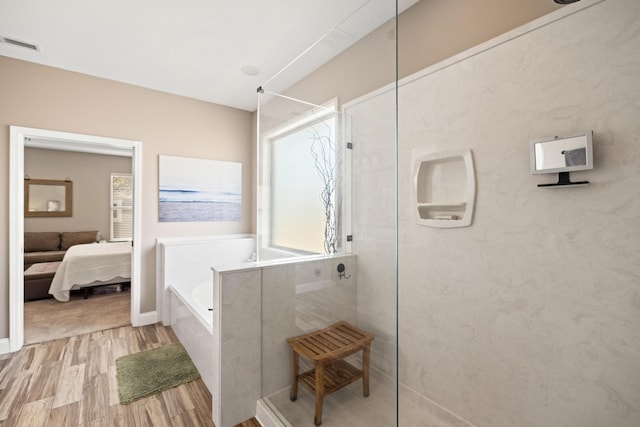 ensuite bathroom featuring visible vents, connected bathroom, wood finished floors, a garden tub, and a walk in shower