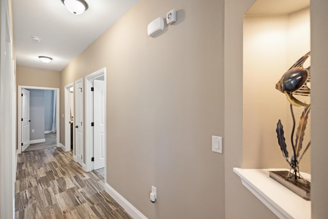 hall featuring baseboards and light wood finished floors