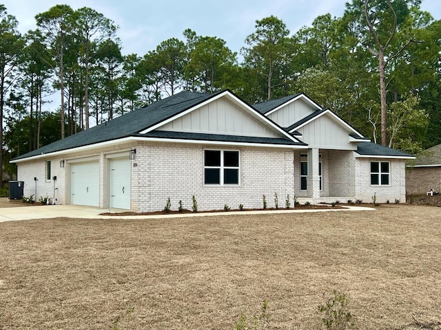 ranch-style house with cooling unit, driveway, a garage, board and batten siding, and brick siding