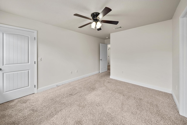 spare room with baseboards, visible vents, carpet flooring, and a ceiling fan