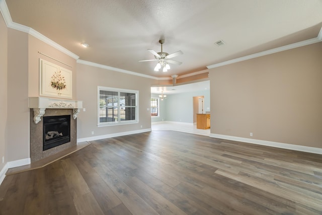 unfurnished living room with baseboards, wood finished floors, a premium fireplace, and ceiling fan with notable chandelier