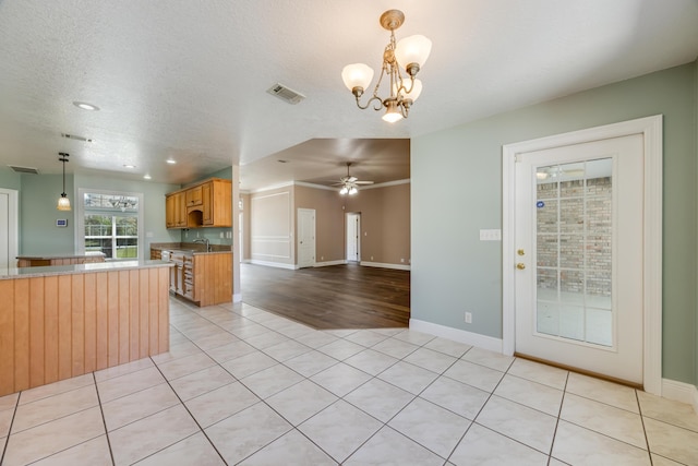 kitchen with light countertops, decorative light fixtures, light tile patterned floors, a textured ceiling, and visible vents