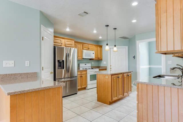 kitchen with visible vents, a sink, light tile patterned floors, and white appliances