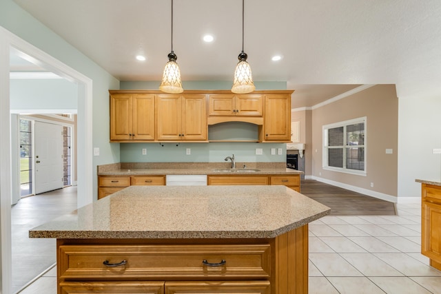 kitchen with a kitchen island, a sink, ornamental molding, and pendant lighting