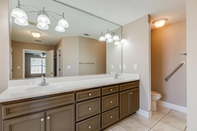 bathroom featuring tile patterned flooring, a sink, toilet, and double vanity
