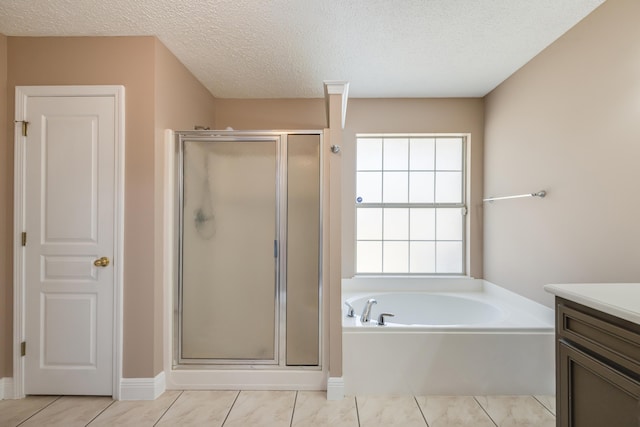 bathroom with a shower stall, a textured ceiling, vanity, and a garden tub