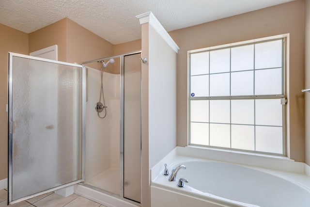 full bathroom with a stall shower, a garden tub, and a textured ceiling