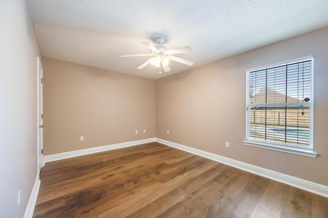 empty room featuring a ceiling fan, a textured ceiling, baseboards, and wood finished floors