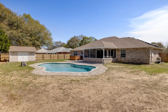 view of swimming pool with a lawn, a sunroom, and a fenced backyard