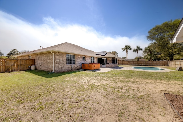 rear view of house featuring a fenced backyard, a sunroom, a patio, and a hot tub