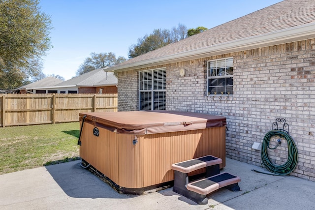 view of patio featuring a hot tub and fence