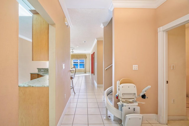 hallway with light tile patterned floors, baseboards, and ornamental molding