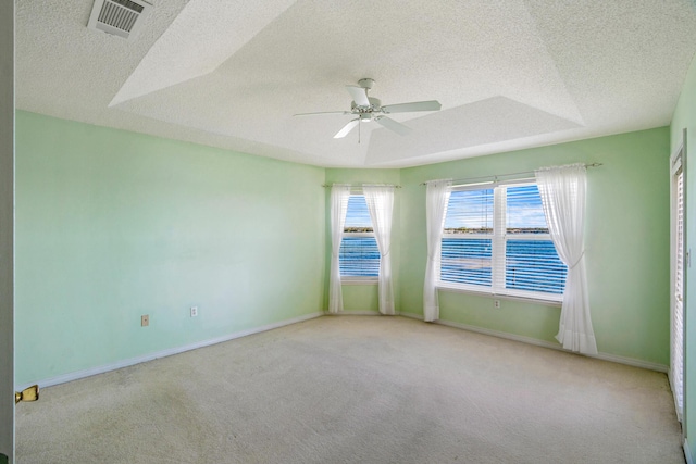 empty room with baseboards, visible vents, ceiling fan, a textured ceiling, and carpet flooring