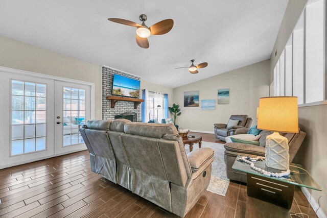 living area with french doors, a brick fireplace, ceiling fan, wood tiled floor, and vaulted ceiling