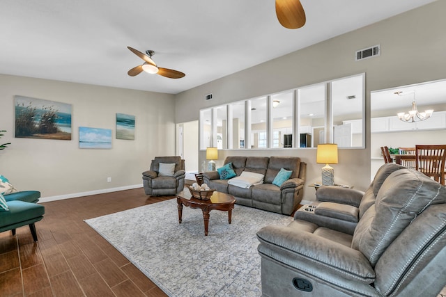 living area with dark wood finished floors, ceiling fan with notable chandelier, visible vents, and baseboards