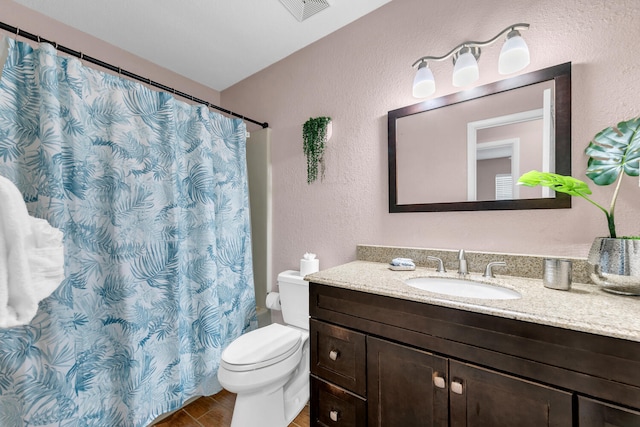 bathroom with vanity, toilet, a textured wall, visible vents, and curtained shower