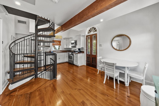 122 W Kingston Rd, Rosemary Beach, FL 32461 - dining area with wood-type flooring, beamed ceiling, stairway, and visible vents